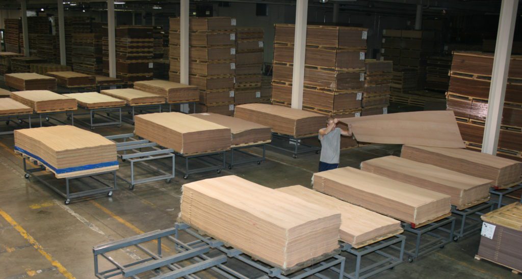 Organizing face wood veneer sheets into pallets.