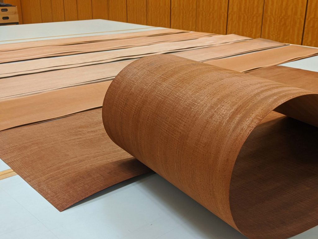 Varying shades of red brown of Figured Mahogany wood veneer samples.